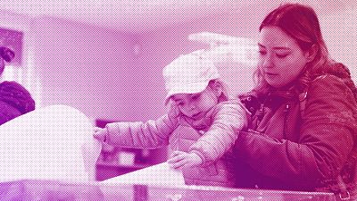 A woman holds a toddler to cast her ballot during parliamentary elections in Warsaw, October 2023
