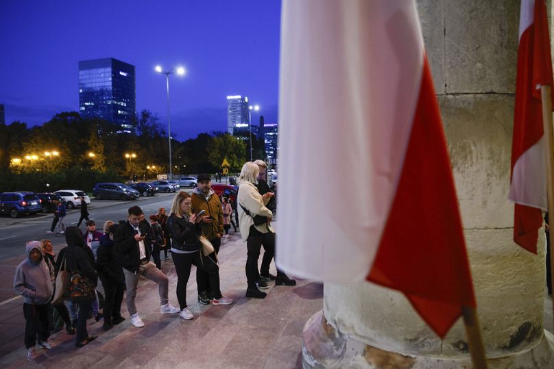 People wait in line to cast their ballot during parliamentary elections in Warsaw, October 2023