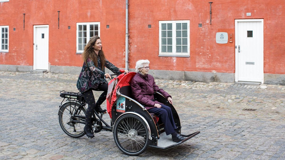 Un volontario e membro dell'associazione "Un Vélo Pour Tous" trasporta un'anziana signora in una cargo bike, il 5 maggio 2019, nel centro di Copenaghen.