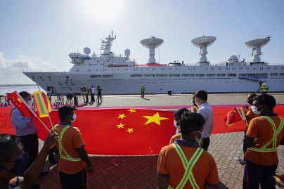 Sri Lankan port workers held China's flag as a Chinese research ship, bristling with surveillance equipment, arrived at Hambantota International Port, on 16 August 2022.