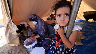 A young girl stands inside one of the tents set up for Palestinians on the grounds of a UNRWA centre in Khan Yunis.