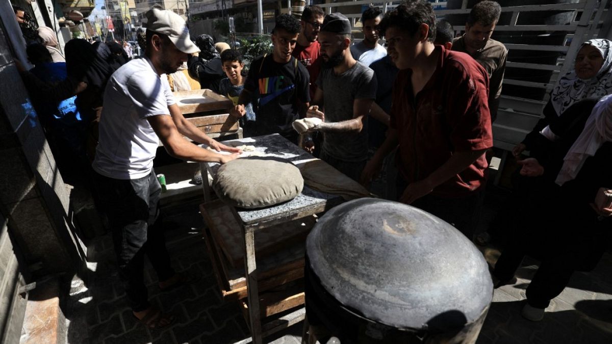 Перемещенные палестинцы стоят в очереди за хлебом на фоне израильских ударов в Хан-Юнисе, на юге сектора Газа, 15 октября 2023 года. 