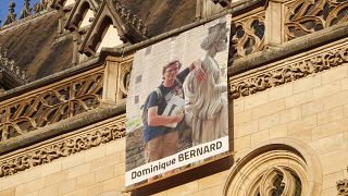 Портрет Доминика Бернара на фасаде собора Арраса, где прошла церемония прощания с убитым чеченским исламистом учителем, 19 октября 2023 г.