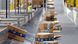 Amazon-Pakete bewegen sich entlang eines Förderbandes in einem Amazon-Lagerhaus am 17\. Dezember 2019 in Goodyear, Arizona