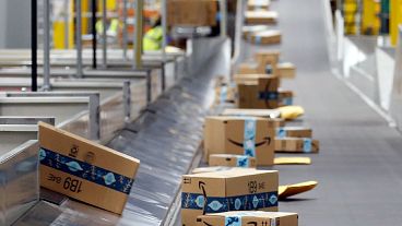 Amazon-Pakete bewegen sich entlang eines Förderbandes in einem Amazon-Lagerhaus am 17\. Dezember 2019 in Goodyear, Arizona