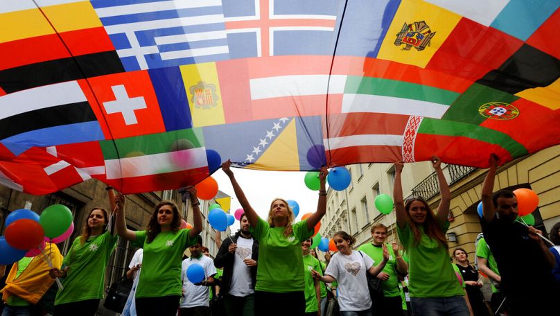 Young people carry a banner with European countries flags during an annual parade to honour Robert Schumann in Warsaw, May 2013