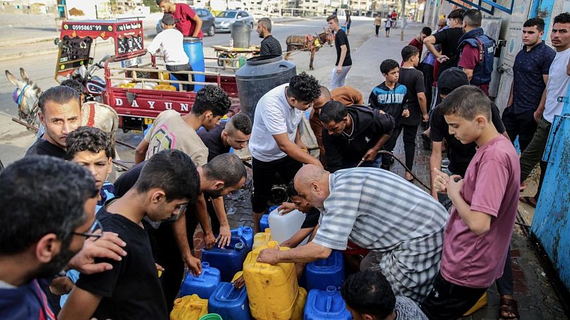 فلسطينيون يتجمعون حول نقطة توزيع المياه الصالحة للشرب في غزة