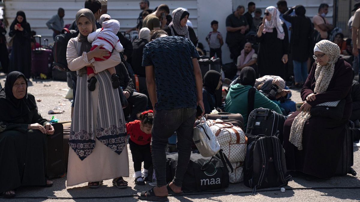 زنان و کودکان فلسطینی در انتظار به امید بازگشایی گذرگاه رفح به سوی مصر در تاریخ ۱۶ اکتبر ۲۰۲۳