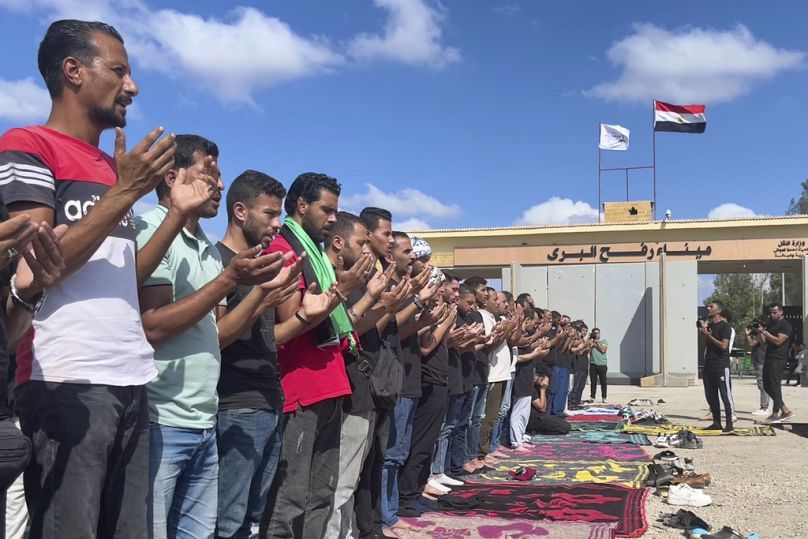 Volontari egiziani pregano per le vittime degli attacchi aerei israeliani su Gaza, al valico di Rafah