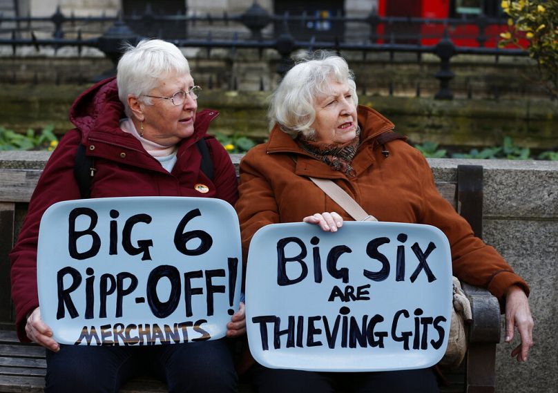 Demonstrators against rising energy prices, hold placards referring to the six UK energy providers, as they gather in London's City financial district, November 2013