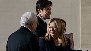 Giorgia Meloni talks to Monsignor Leonardo Sapienza, left, as she arrives with her partner Andrea Giambruno, second from left, at The Vatican, Tuesday, Jan. 10.