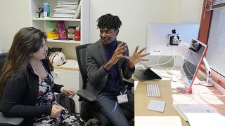 Post-doctoral researcher Tofunmi Omiye, right, gestures while talking in his office with assistant professor Roxana Daneshjou at the Stanford School of Medicine.