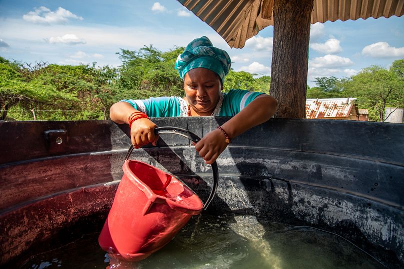 Mónica Lopez, Wayuu leader, collecting drinking water from a tank in La Guajira.