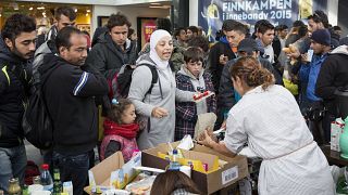 توزيع الطعام والشراب من قبل متطوعين على اللاجئين بعد وصولهم إلى محطة القطار في مالمو، السويد