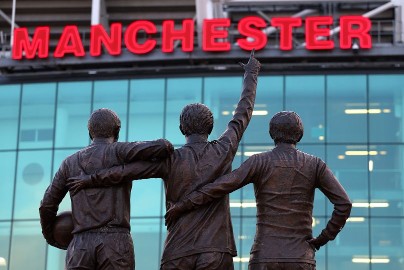 The statues of Sir Bobby Charlton, George Best and Denis Law are seen outside the Manchester United stadium