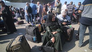 فلسطينينون ينتظرون في معبر رفح لمغادرة قطاع غزة.
