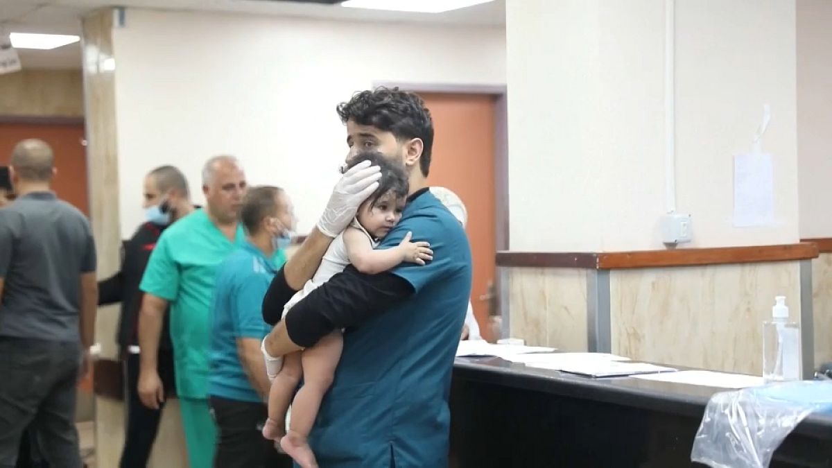 طبيب يحمل طفلا مصابا