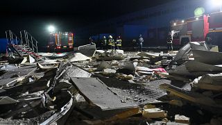  Ukrainian rescuers work among the debris of a mail depot building following missile strikes at the village of Korotych in Kharkiv region