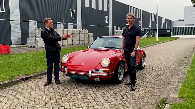 Jack Parrock (li.) mit Martijn Van Dijk vor einem alten Porsche mit Elektro-Antrieb