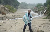 A man walks on the mud caused by hurricane Norma in San Jose del Cabo, Mexico, Saturday, Oct. 21, 2023. Norma