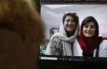 A woman looks at a picture of Iranian reporters Niloufar Hamedi and Elahe Mohammadi 