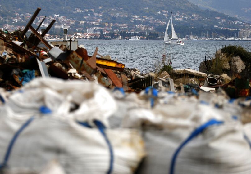 A boat sails near a pile of jumbo bags filled with trash in an shipyard in Bijela, November 2014