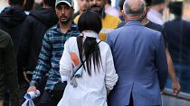 ARCHIVO: Una mujer camina en Teherán con el pelo descubierto, abril de 2023