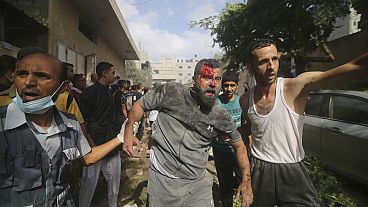 Des Palestiniens évacués des bâtiments touchés lors du bombardement israélien sur la bande de Gaza à Rafah, dimanche 22 octobre 2023.