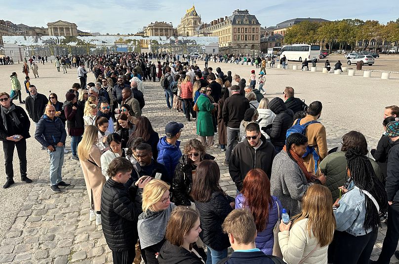 ourists queue to enter the Chateau de Versailles (Versailles Palace) after it was evacuated for security reasons on 17 October.