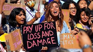  Мици Джонел Тан (в средата), филипински деятел за климатична правдивост, се причислява към митинг, призоваващ за нов фонд за загуби и вреди на COP27. 
