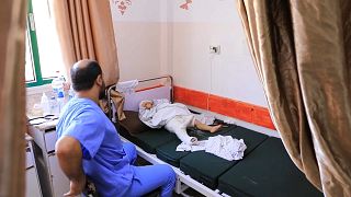 O médico Nour el-Din al-Khatib junto de uma criança vítima da guerra em Gaza