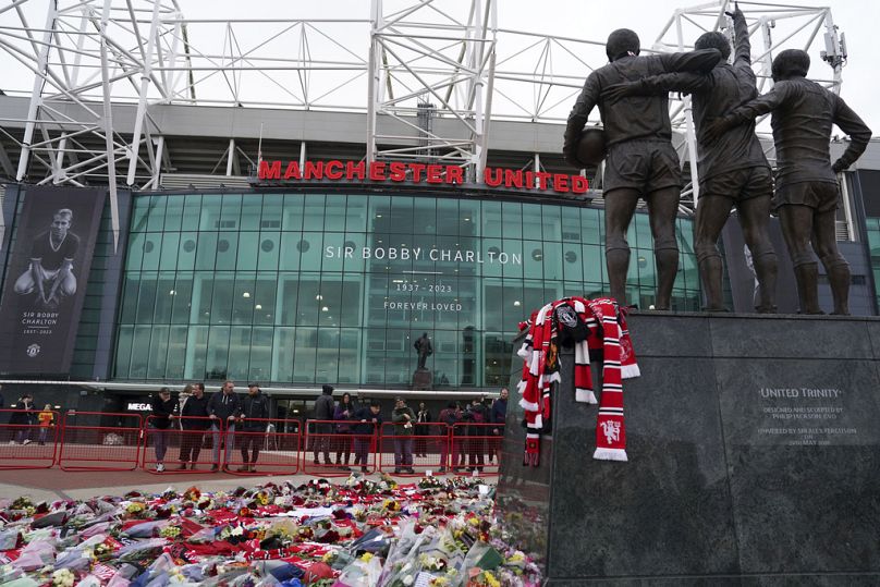 Floral tributes to Bobby Charlton are placed at Old Trafford stadium, Manchester, Engand, Monday Oct. 23, 2023.