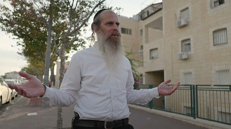 An Israeli man wears a side arm in the street. October 2023