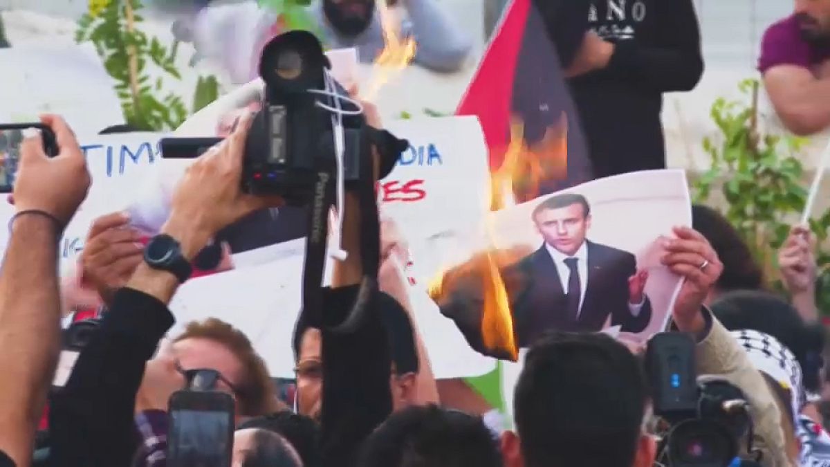 متظاهرون يحرقون صورة للرئيس الفرنسي إيماويل ماكرون أثناء زيارته للضفة الغربية .24 تشرين الأول 2023.