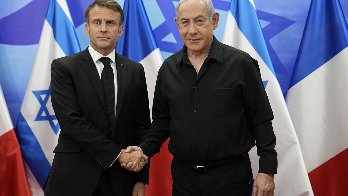 Israeli Prime Minister Benjamin Netanyahu, right, welcomes French President Emmanuel Macron before their talks in Jerusalem, Tuesday, Oct. 24, 2023.
