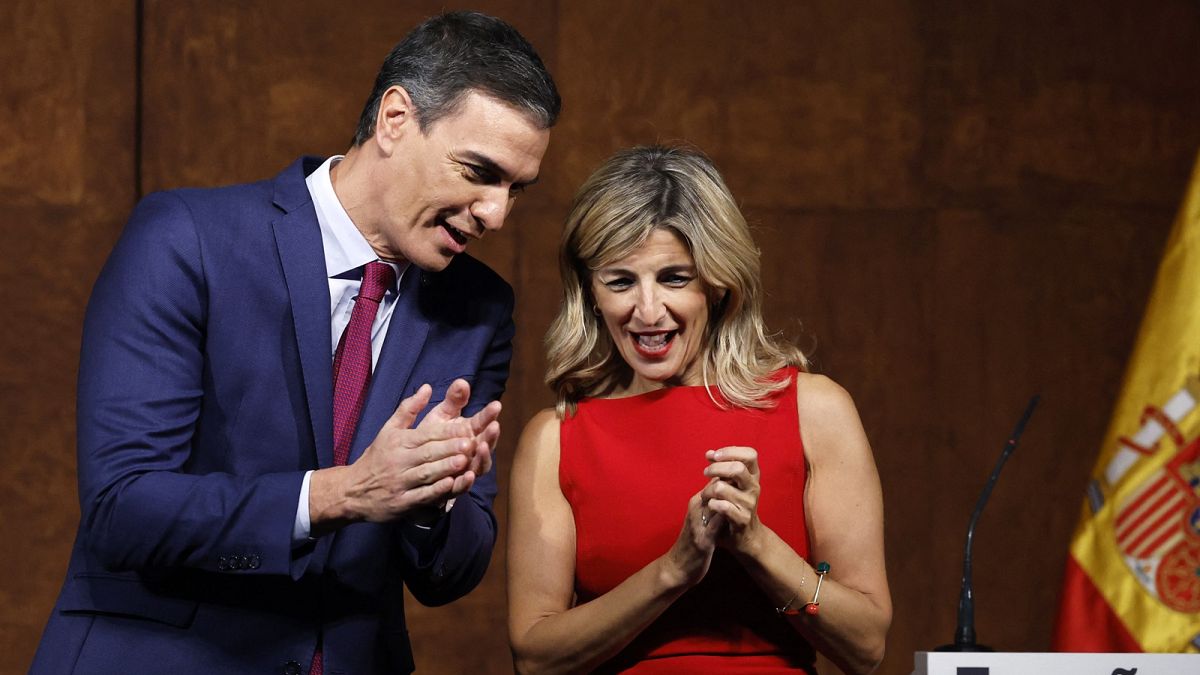 Spain's acting Prime Minister Pedro Sanchez (L) and the founder of Sumar, Yolanda Diaz, applaud after signing an agreement to form a coalition government.
