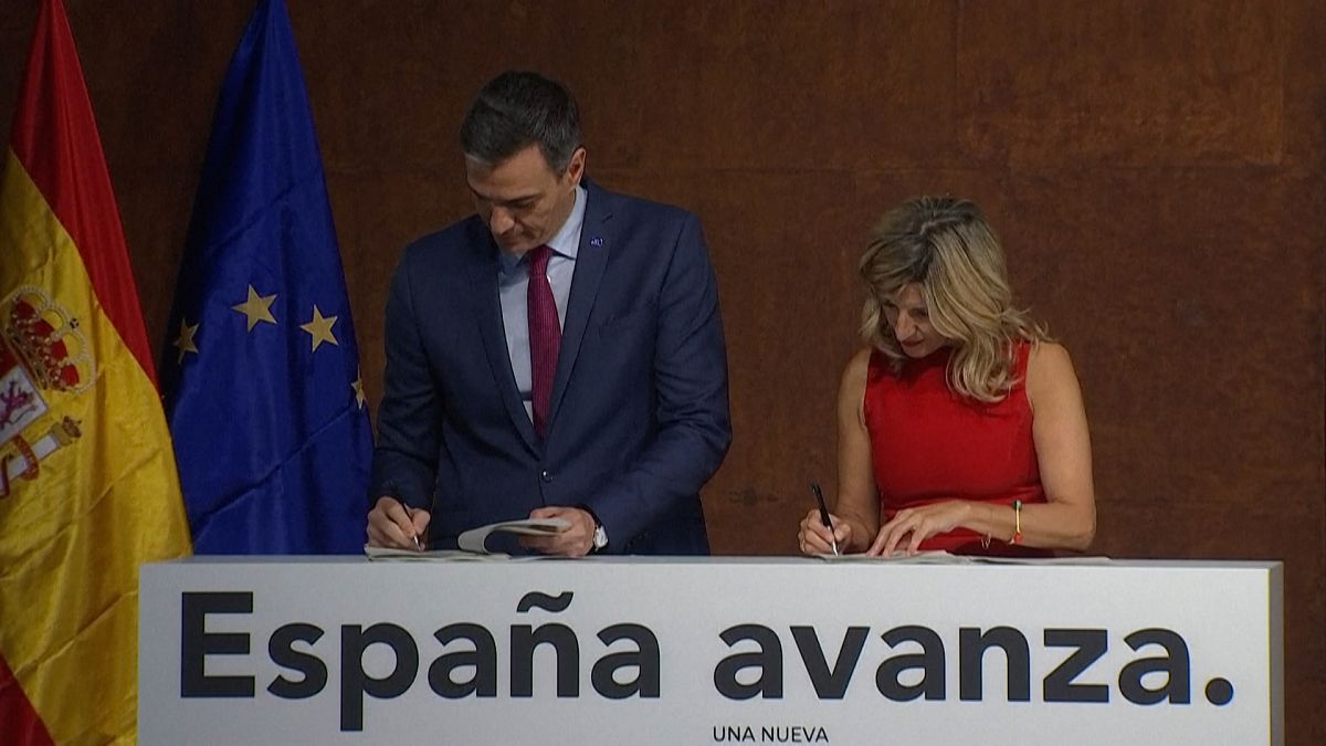 El presidente de España (izquierda), y la ministra de Trabajo durante la firma del acuerdo de coalización.