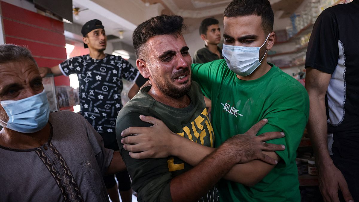 رجل فلسطيني أحد أقاربه إثر غارة إسرائيلية في غزة