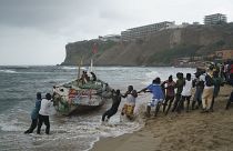 يعمل الناس معًا لانتشال القارب المقلوب إلى الشاطئ