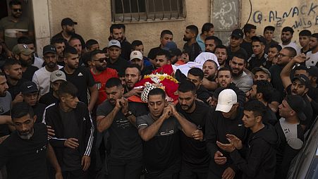 Mourners carry the body of Ahmad Muteir during his funeral in the West Bank refugee camp of Qalandia, south of Ramallah, Wednesday, Oct. 25, 2023. 