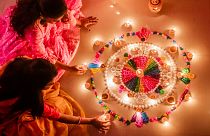 Women holding candles during Diwali festival