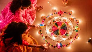  Жени, държащи свещи по време на фестивала Дивали 