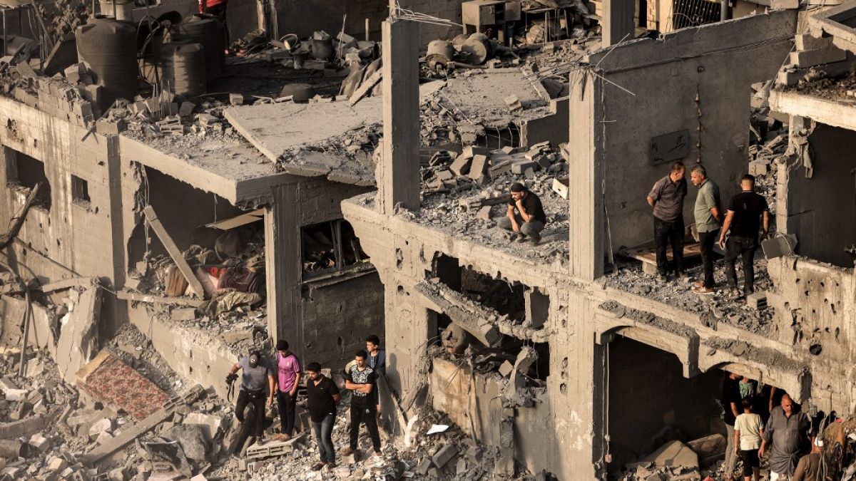 Persone cercano sopravvissuti dopo i bombardamenti israeliani del 25 ottobre a Khan Younis