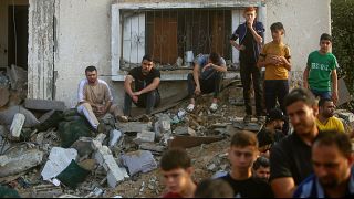 Palesztinok egy izraeli légitámadásban összedőlt ház romjai között a Gázai övezet déli részén lévő Hán Juniszban 2023. október 24-én.
