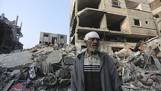Um palestiniano diante de um edifício destruído em Rafah