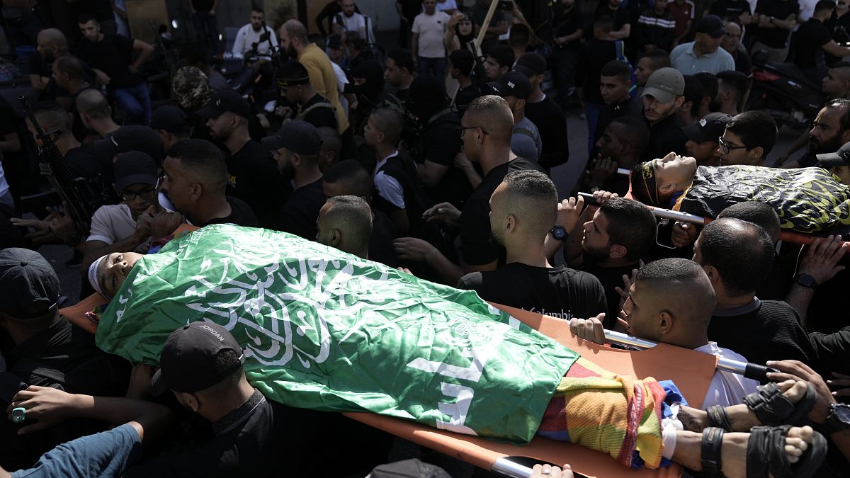 فلسطينيون يحملون جثث نشطاء قتلوا في غارة جوية إسرائيلية على مخيم اللاجئين في جنين