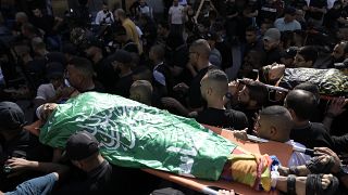 فلسطينيون يحملون جثث نشطاء قتلوا في غارة جوية إسرائيلية على مخيم اللاجئين في جنين