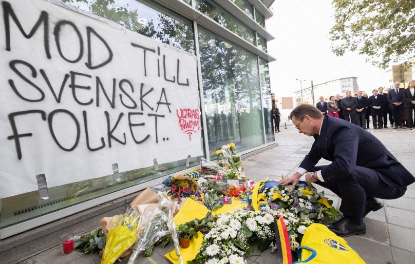 Il primo ministro svedese Ulf Kristersson depone fiori durante una commemorazione delle vittime dell'attacco terroristico