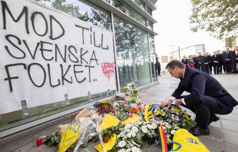 El primer ministro sueco, Ulf Kristersson, entrega flores durante un homenaje de las víctimas del ataque terrorista.