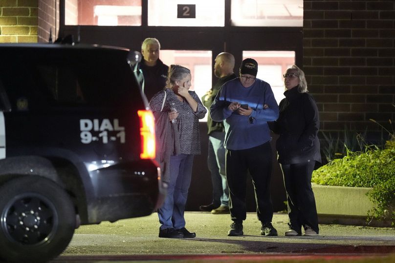 People depart a reunification center early Thursday, Oct. 26, 2023, at Auburn Middle School in Auburn, following shootings at a bar and a bowling alley in Lewiston, Maine.